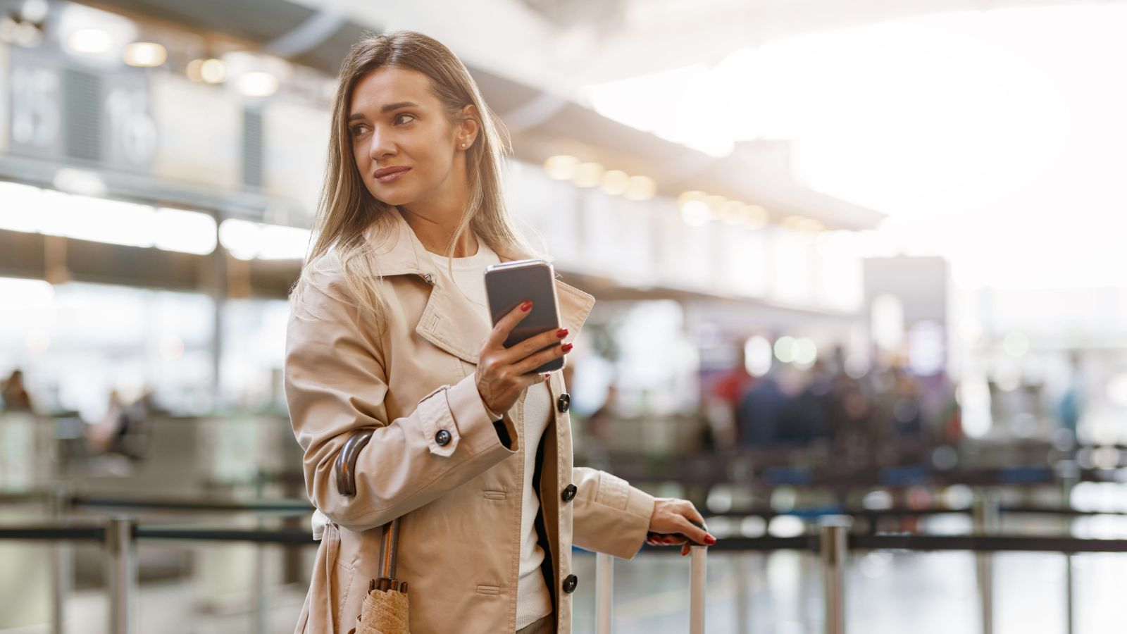 A photo of a confident traveler walking through airport or city with small carry on relaxed minimalist travel lifestyle candid.