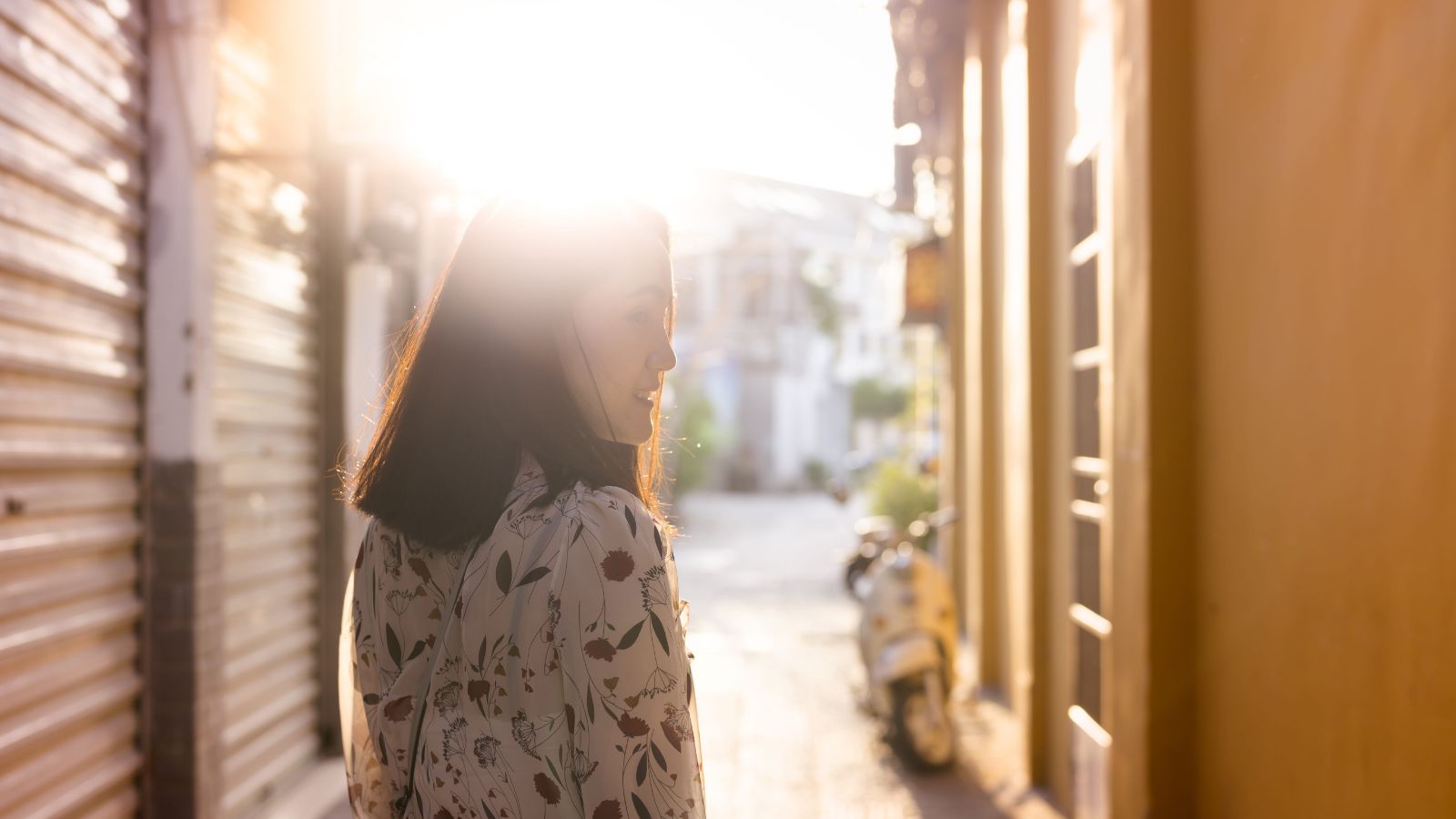 A photo of a traveler slowly walking through a scenic historic street during golden hour, relaxed and enjoying the atmosphere.