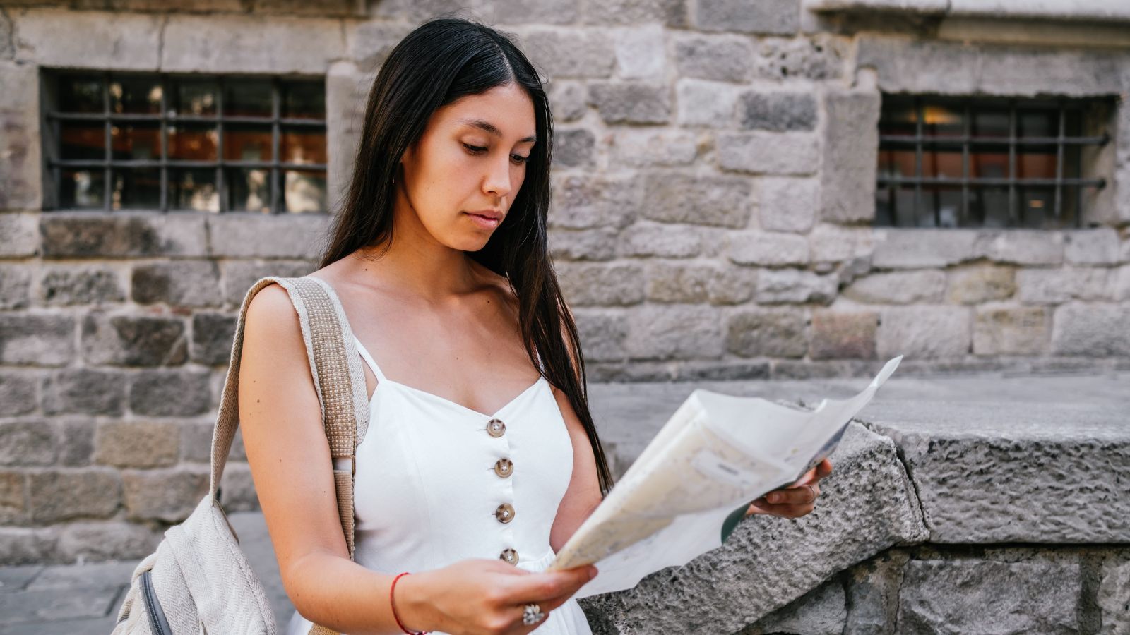 A photo of a traveler looking at map or itinerary thoughtfully planning travel calm natural light candid flat lay.