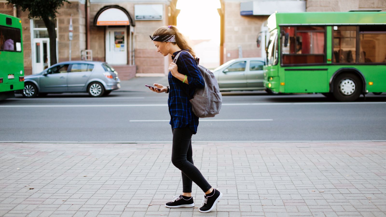A photo  of a traveler walking long distance in a Canadian city street looking tired from uncomfortable shoes.