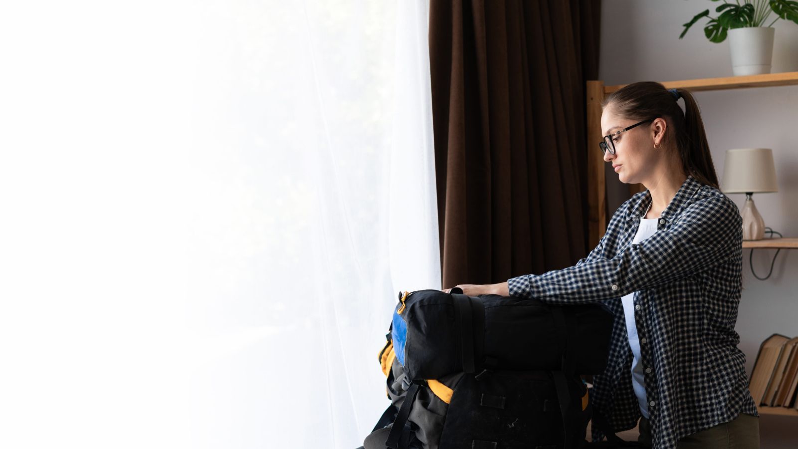 A photo of a traveler packing suitcase in hotel room looking tired frequent checkouts travel fatigue cluttered luggage.