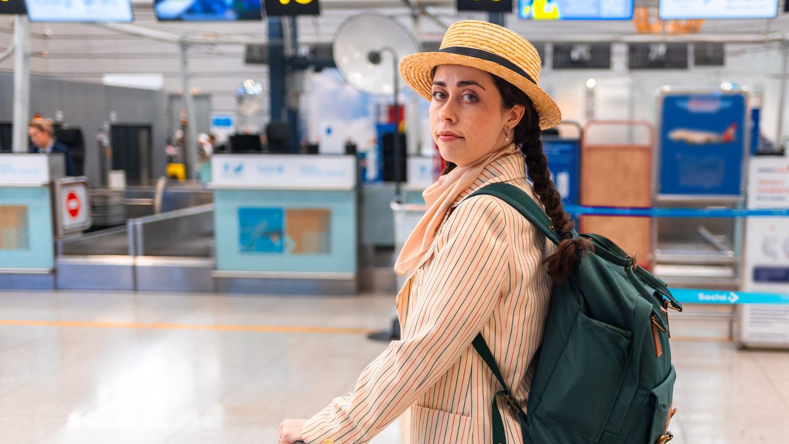 A photo of a traveler arriving at destination airport or city with luggage looking tired but hopeful first day travel natural light candid.
