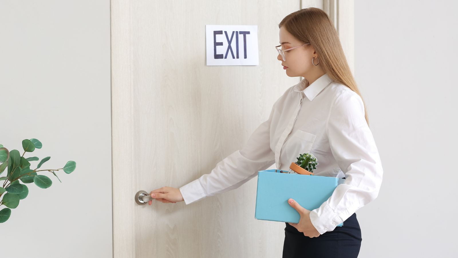 A photo of traveler standing calmly in quiet hotel hallway reviewing nearest exit sign and stairwell location.