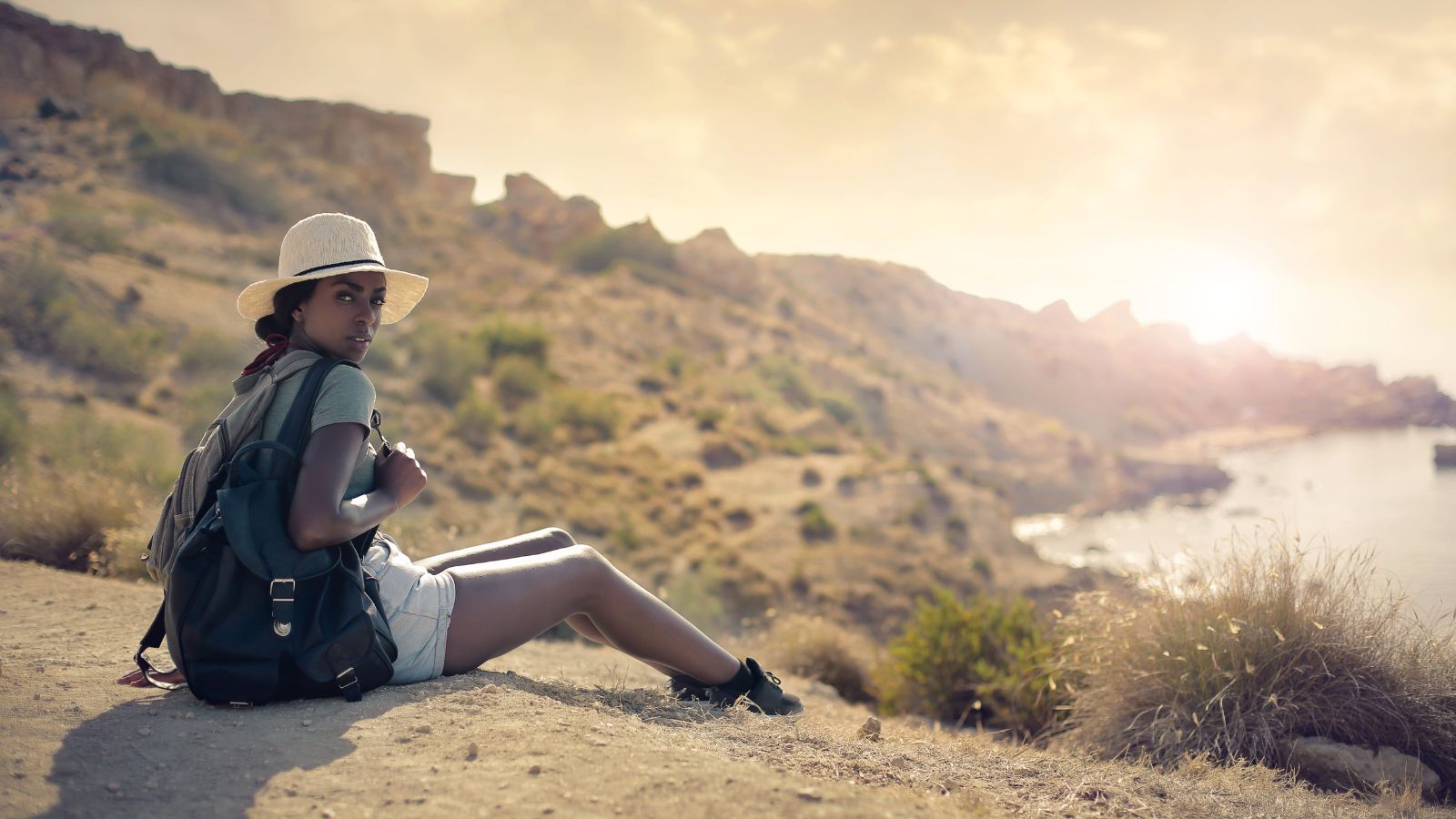 A photo of a traveler sitting peacefully overlooking scenic view calm serene environment fully relaxed travel moment.