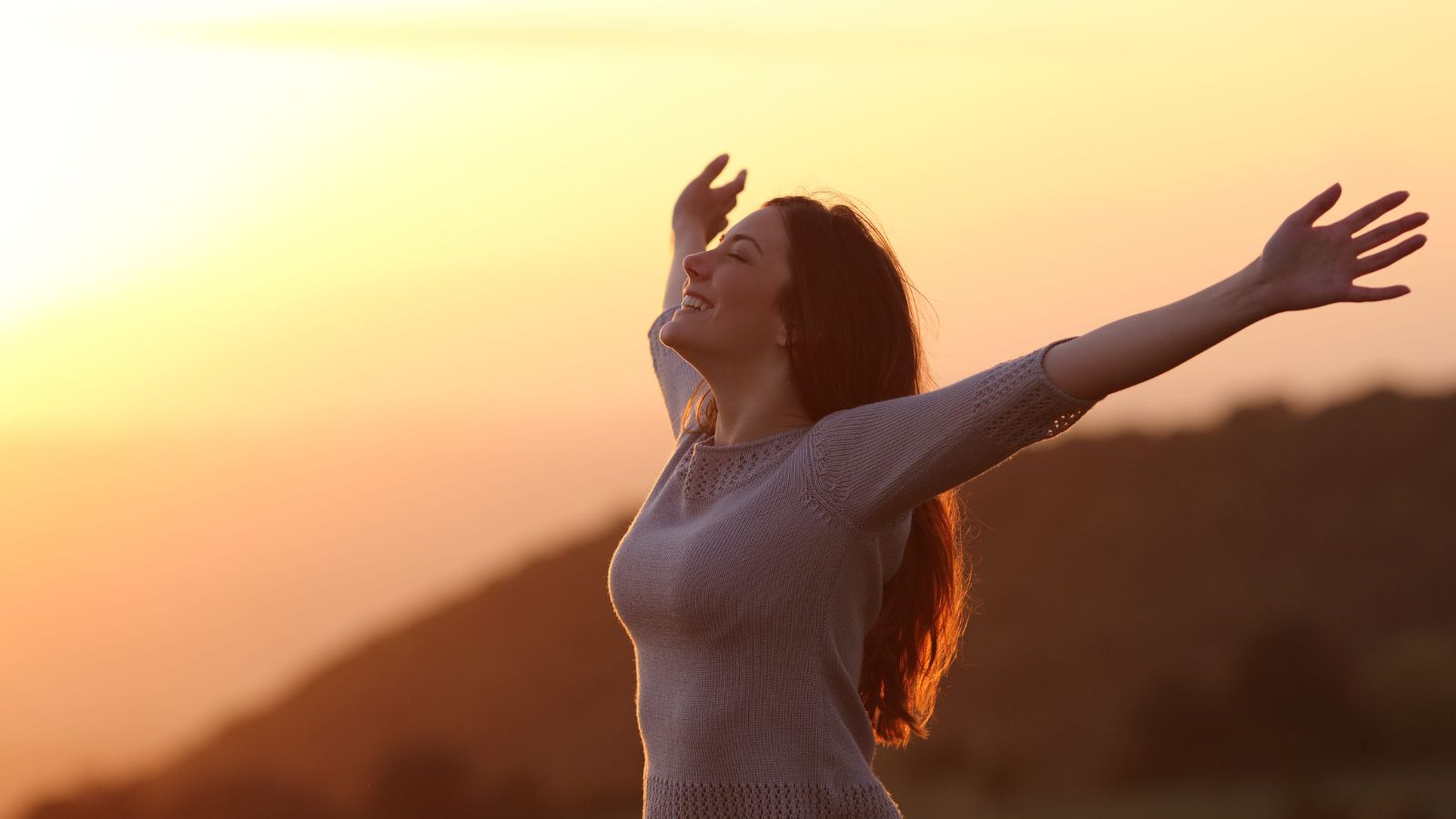 A photo of a woman enjoying the sunset.