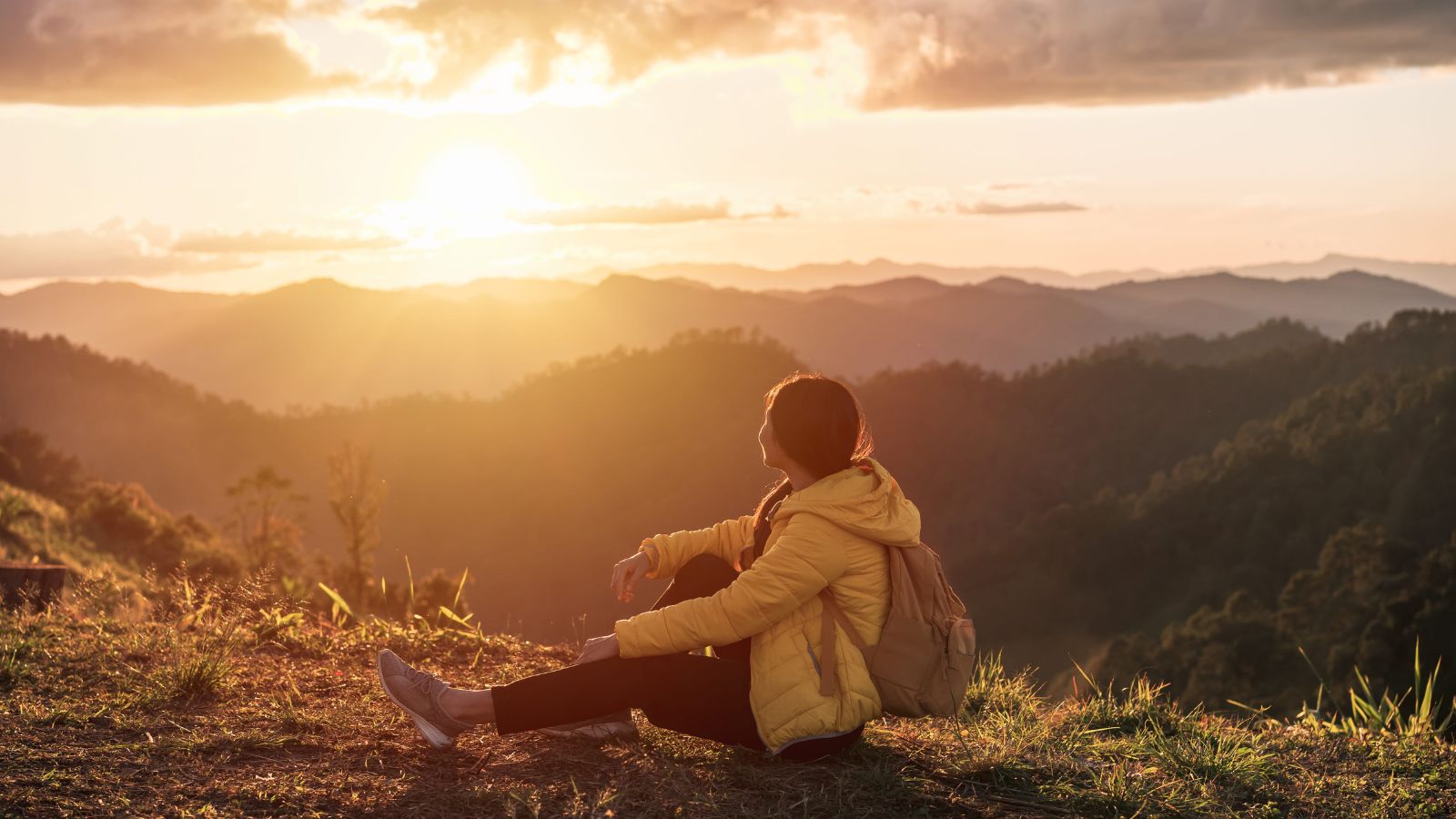 A photo of a solo traveler enjoying scenic view mountains or city overlook peaceful minimalist travel lifestyle sunset.