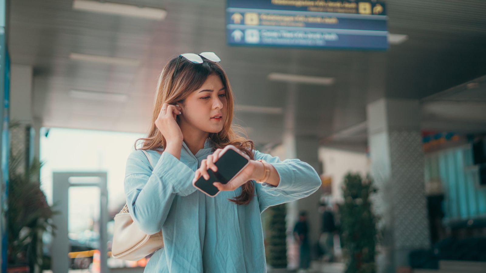 A photo of a traveler sitting calmly at airport or station waiting area relaxed unhurried checking time with ease peaceful travel moment natural light candid.