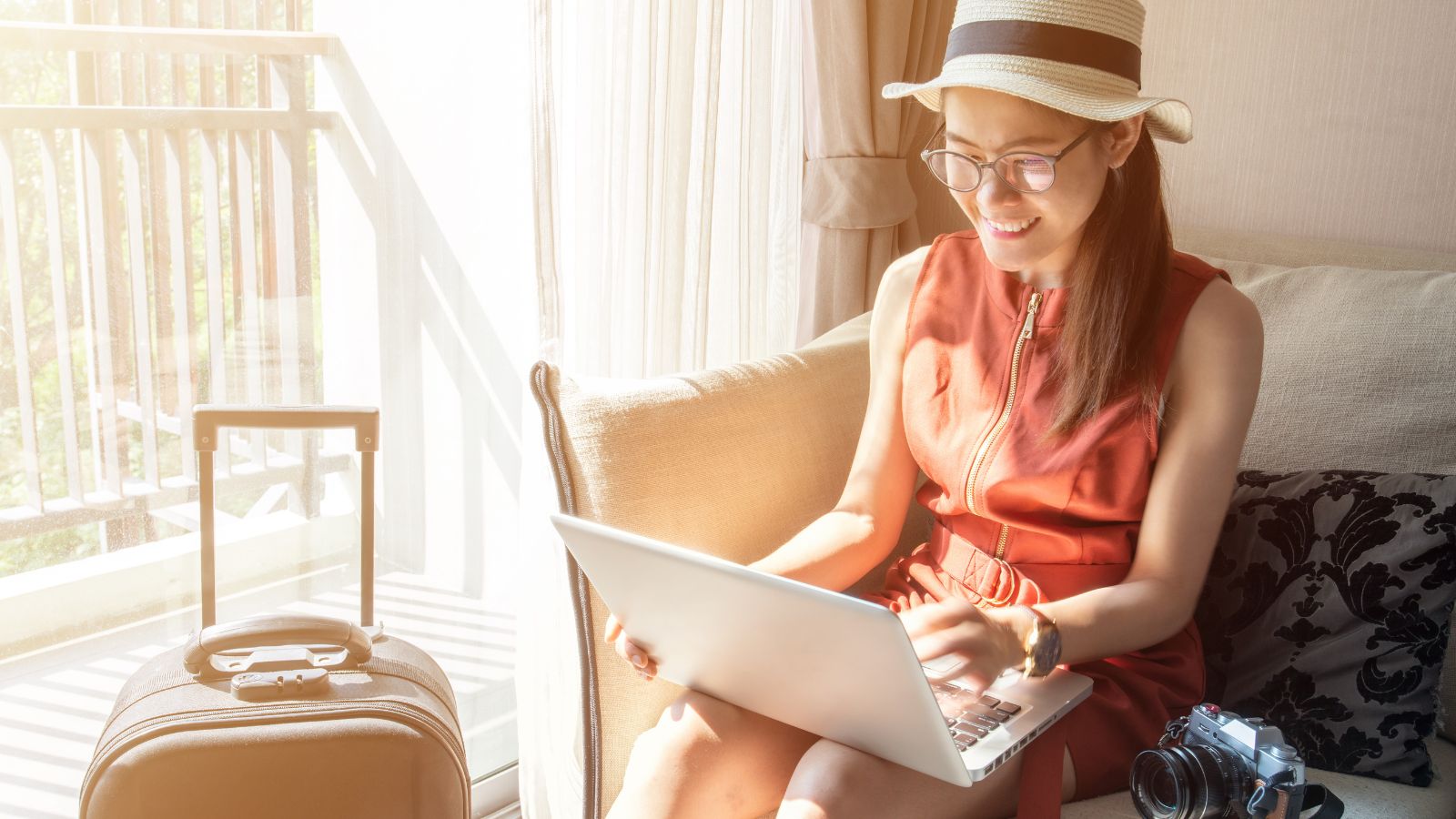 A photo of a woman sitting, holding a map with a luggage beside her.
