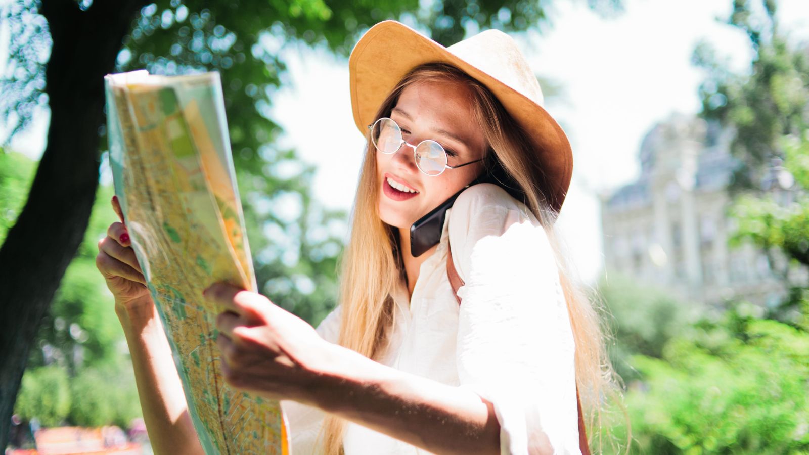 A photo of a traveler looking at map or phone with multiple destinations planned looking slightly overwhelmed.