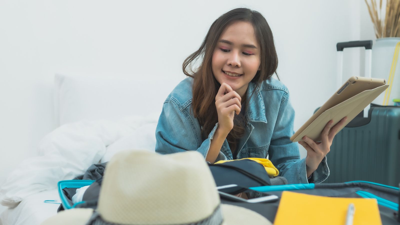 A photo of a traveler packing a small suitcase on a bed with travel essentials and passport, planning a European trip.