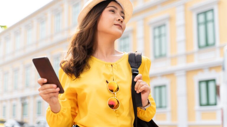 A photo of a tourist walking fast in city checking watch or phone stressed tired travel busy schedule candid.