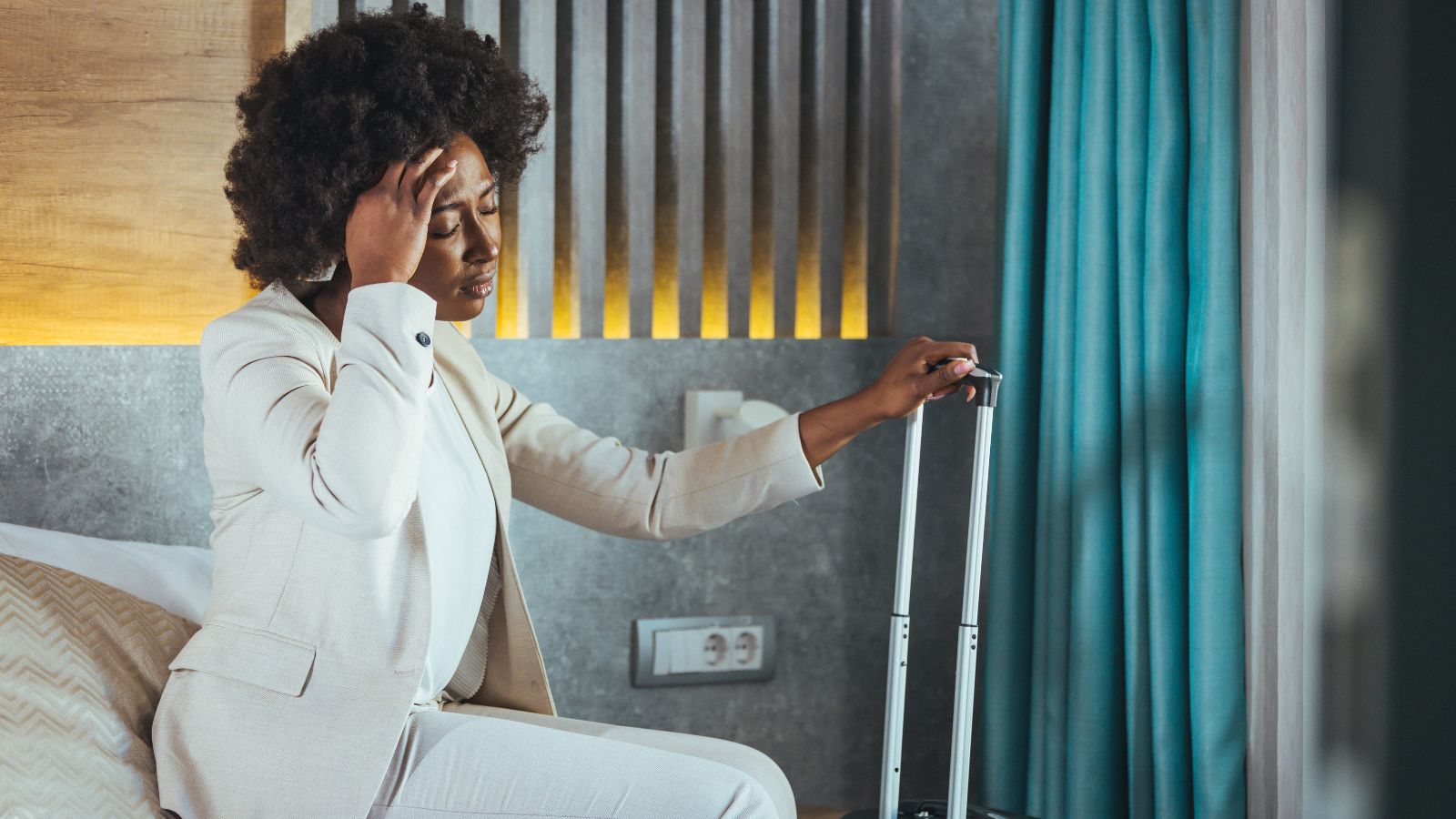 A photo of a traveler in upscale hotel room looking slightly annoyed reacting to noise or inconvenience.