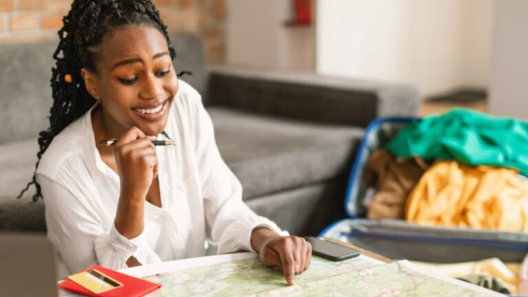 A photo of a woman sitting at the floor facing the map.