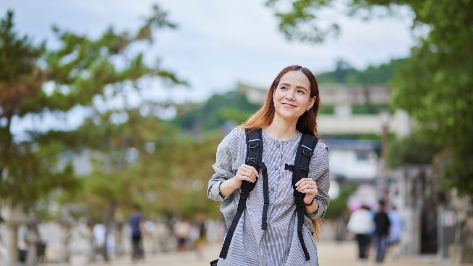 A photo of a solo traveler walking leisurely along scenic path or park enjoying peaceful moment relaxed calm balanced travel experience natural light candid.