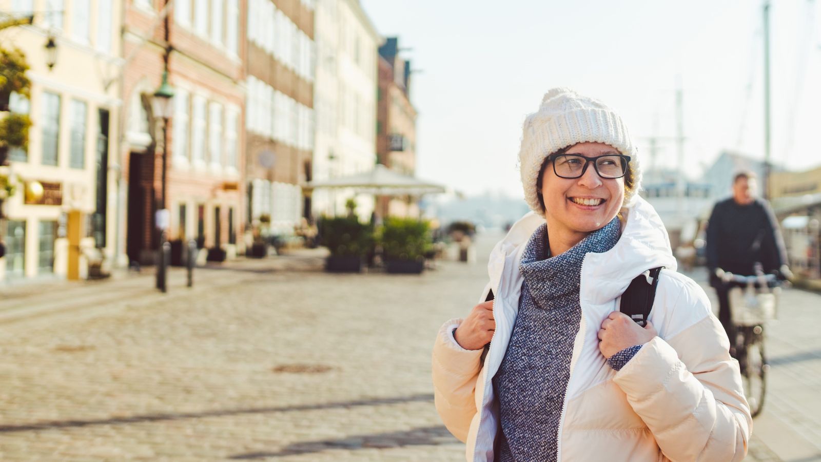 A photo of a traveler walking in a Canadian city wearing layered clothing.